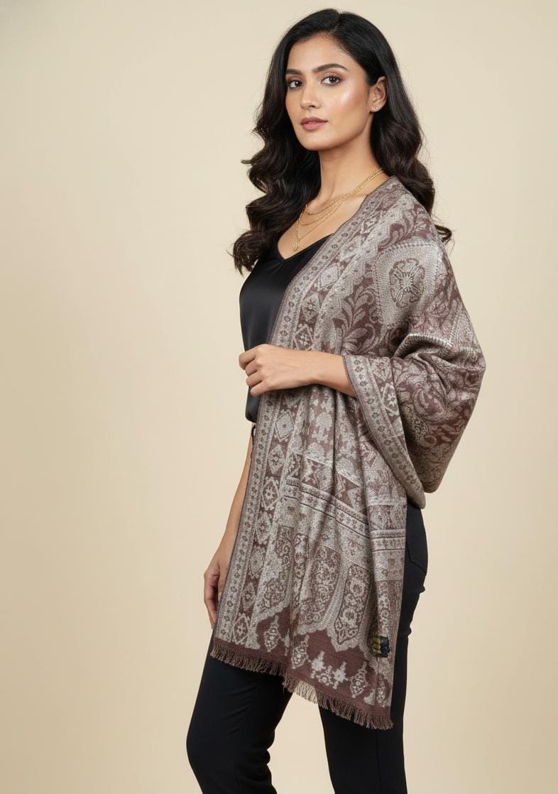 Woman in a black silk top wearing a cocoa and silver-grey Kaani pashmina shawl with intricate heritage weaving.